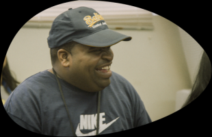 Man laughing wearing navy hat and t-shirt