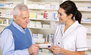 Pharmacist serving senior man in pharmacy — Pharmacy in Oxnard, CA