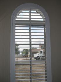 Three windows with arch top shutters