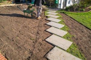 Removal of old turf around a new steppingstone walkway in preparation for the installation of a new turf lawn. ...