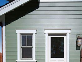 Image of painted green bodyguard siding an trim boards installed on house